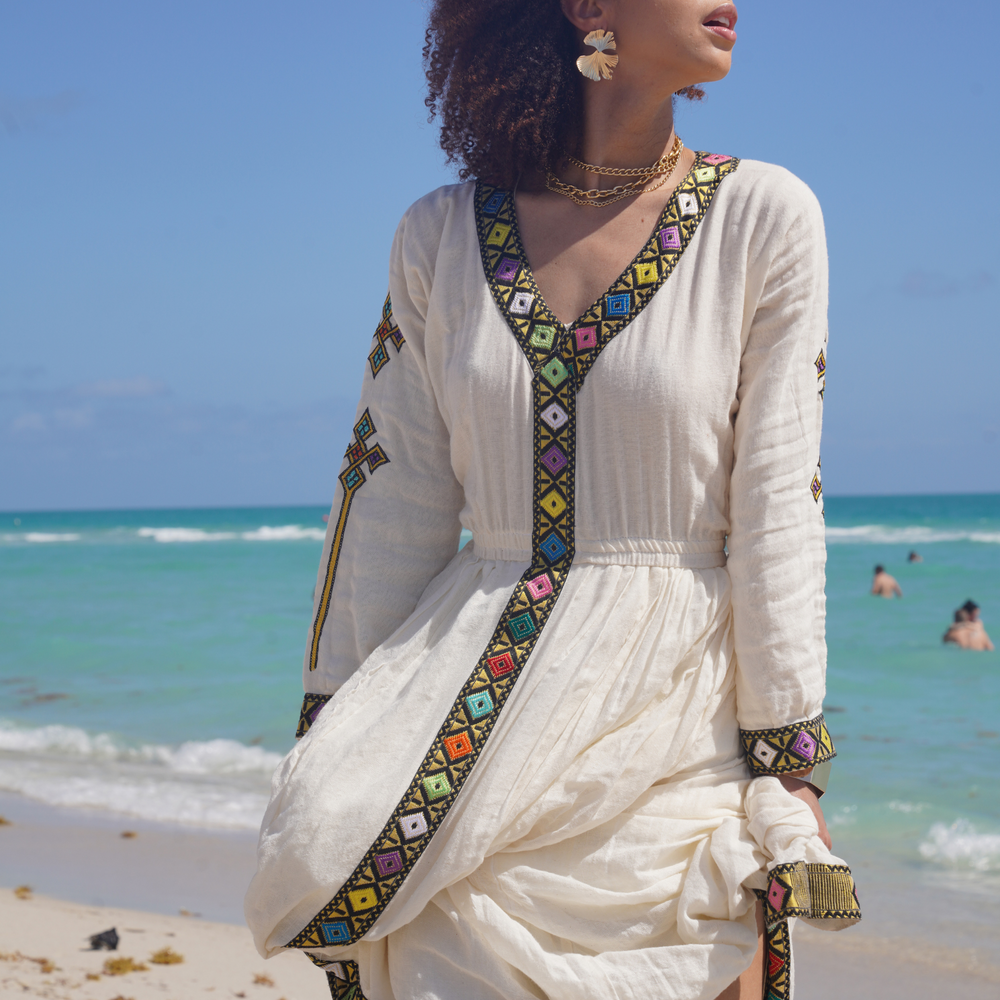 
                  
                    The Nigisiti Dress is a stunning, handwoven and hand-embroidered dress made with 100% Ethiopian cotton. It's flowing, loose design makes it perfect for vacations, holidays, and special occasions. The intricate embroidery is done by hand, making each piece unique and one-of-a-kind. It's a beautiful and comfortable choice for anyone looking to make a statement at their next event or vacation.konjohabeshaAuthentictilif handmadefall2023fashionShamayim
                  
                