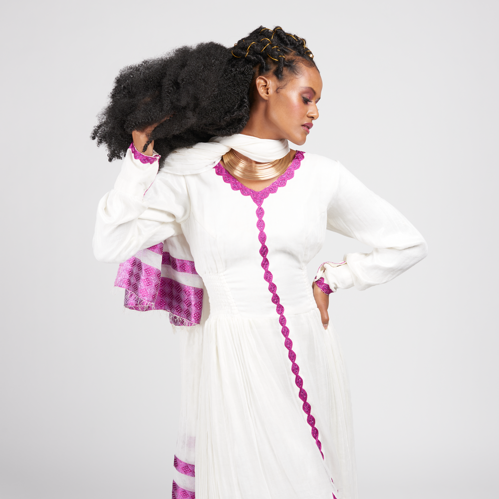 
                  
                    Lilac Dress: Ankle-length with structured waistline and attached scarf. Abyssinian cross detailing. Perfect for Black History Month and Valentine's Day. Length: 145 cm (Size Small). Full Sleeve. 100% Cotton. Care: Dry Clean or Hand Wash.
                  
                