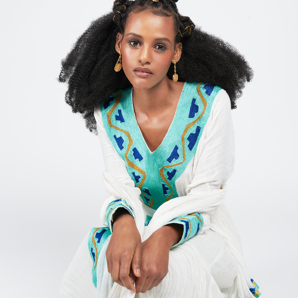 
                  
                    Azeb dress, a traditional Ethiopian garment with Alem Tibeb (Ethiopian Embroidery), celebrates Black History Month and Valentine's Day. V-neck, full sleeves, 100% cotton. Includes Netela (Scarf). Perfect for special occasions. Dry clean or hand wash.
                  
                