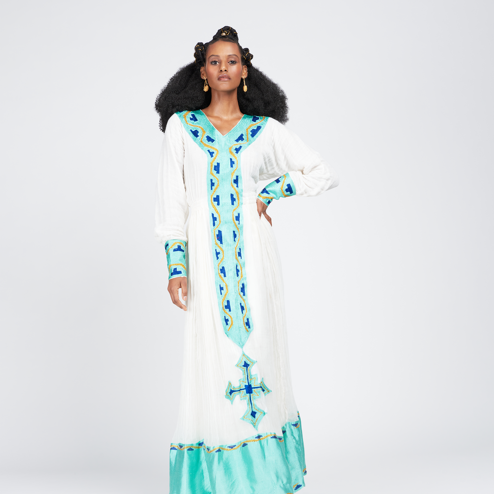 Azeb dress, a traditional Ethiopian garment with Alem Tibeb (Ethiopian Embroidery), celebrates Black History Month and Valentine's Day. V-neck, full sleeves, 100% cotton. Includes Netela (Scarf). Perfect for special occasions. Dry clean or hand wash.